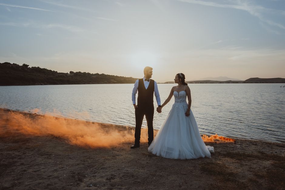 A newlywed couple embracing during sunset